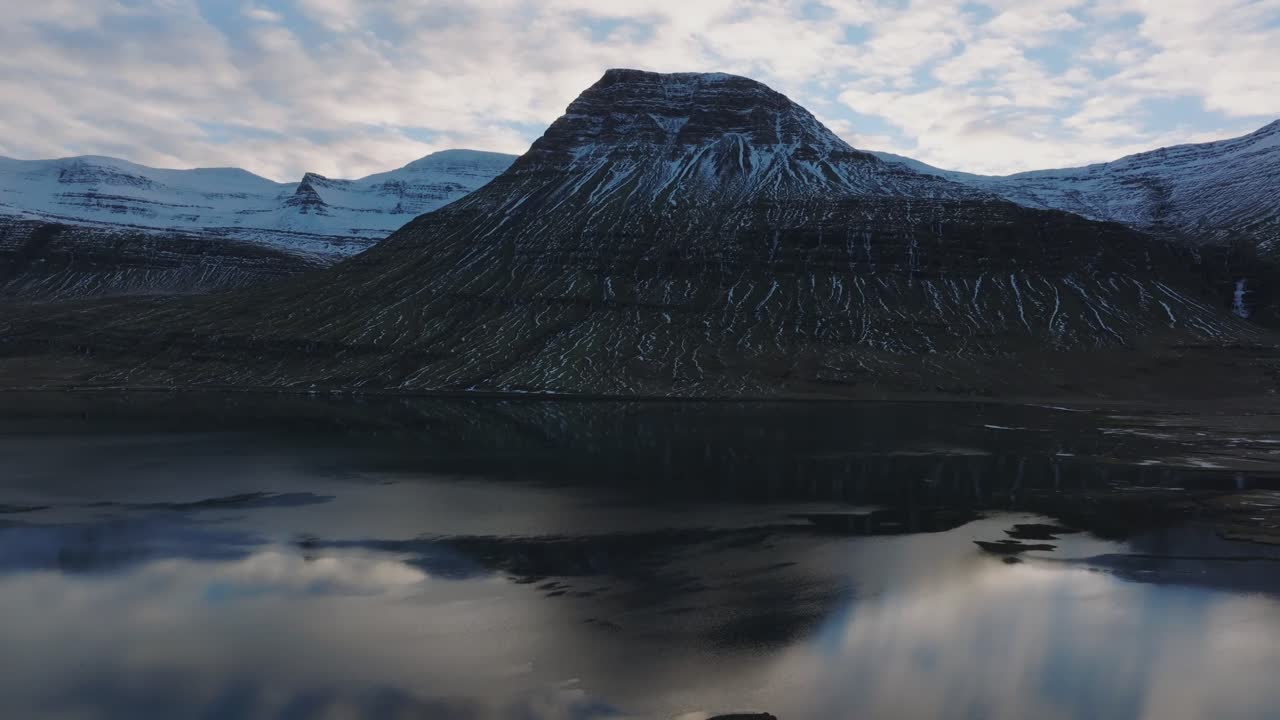 Ilmakuva heijastuvista pohjoismaisista vuorista vuonon vedessä Reyðarfjörðurissa, Islannissa