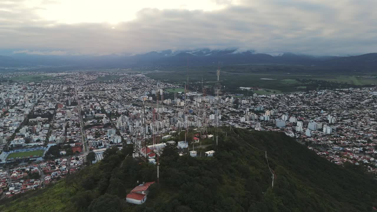 드론을 추적하는 통신 안테나가 태양이 지는 동안 살타의 산 위에 있습니다.