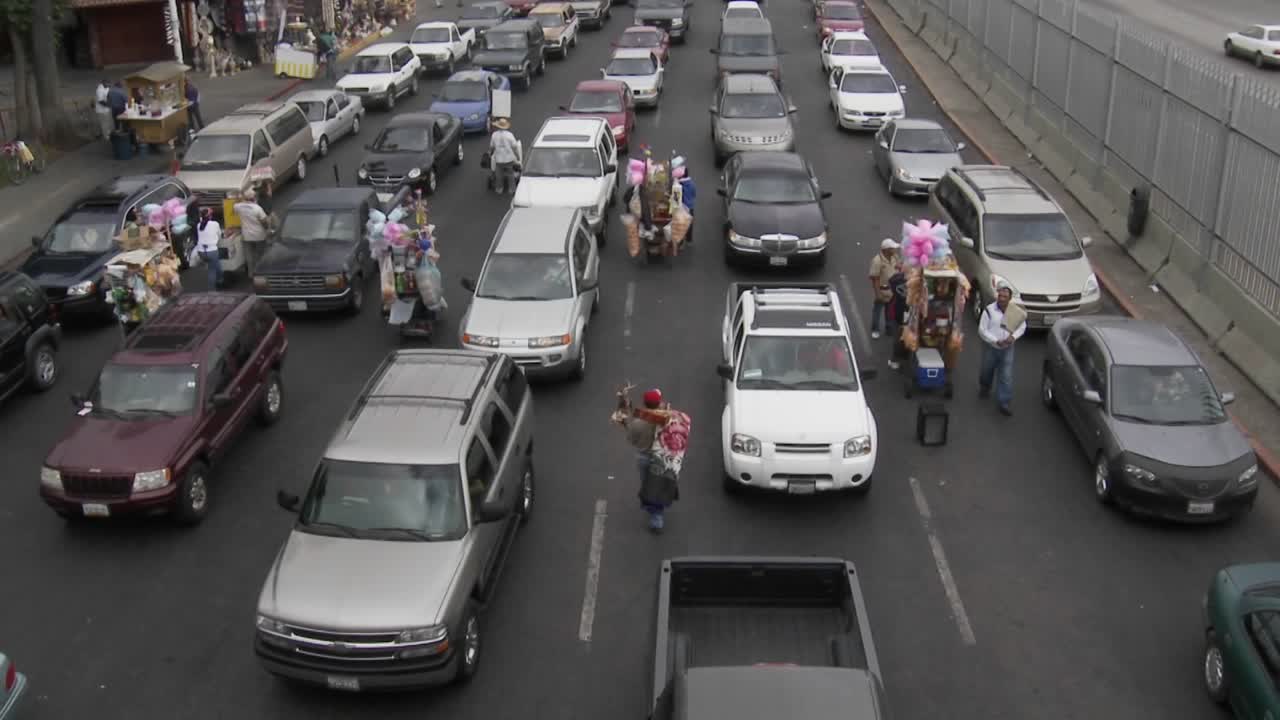 자동차가 티후아나에서 미국으로 다시 건너가기를 기다리는 동안 공급 업체가 상품을 호크합니다.