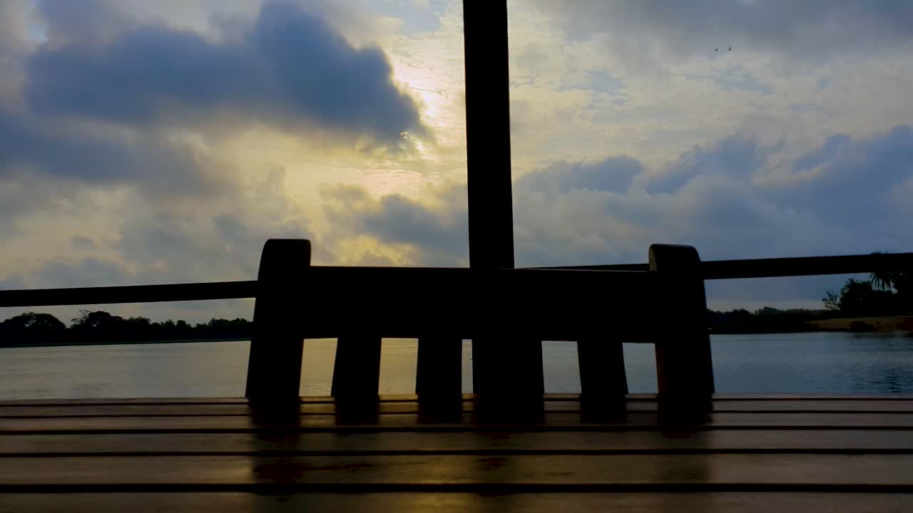 Clouds moving and uncovering the sun. Different perspective view from open wooden deck.