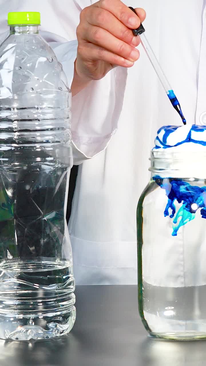A scientist demonstrates a chemical reaction using shaving cream, dye, and a pipette in a laboratory setting