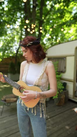 two women playing ukulele outdoors