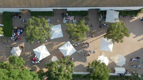 Aerial-view-of-outdoor-wedding-venue-with-groups-of-people-enjoying-the-party-during-sunset