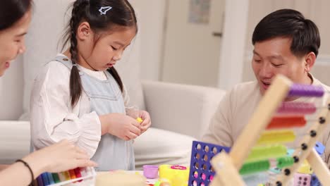 A family engages in creative play with clay and educational toys, fostering learning and bonding in a warm, well-lit setting