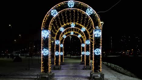 illuminated archway in a winter park at night