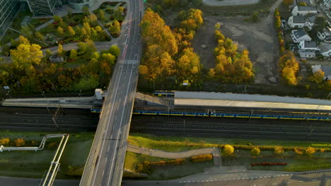 moving train on gdynia railway over highway bridge at sunrise