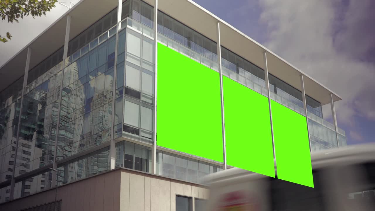 Facciata di edificio moderno con grande cartellone pubblicitario con schermo verde