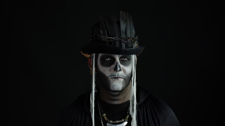 Uomo sinistro con trucco da scheletro di Halloween che gira la testa e guarda in camera, cercando di spaventare.