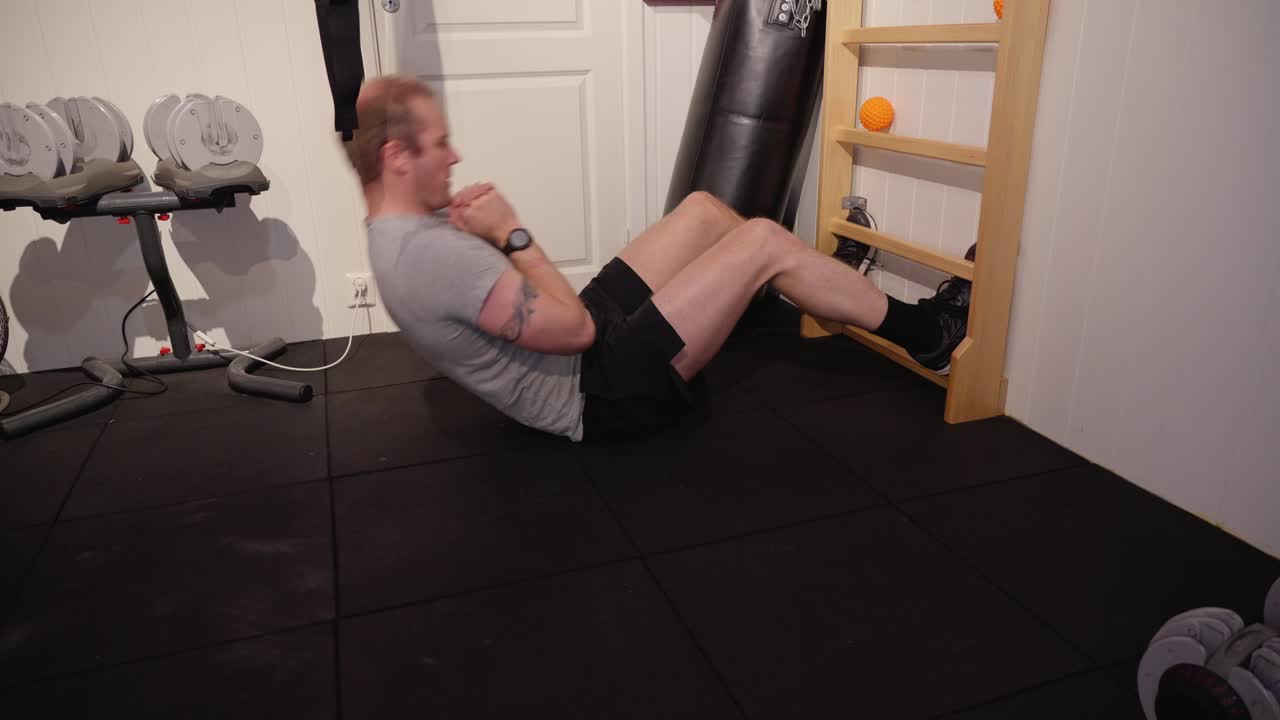 hombre realizando abdominales regulares en la pared de las costillas en el gimnasio casero para construir la fuerza y la aptitud del núcleo. ejercicio en interiores