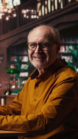 vertical video senior man at university wearing glasses reading documents with focus