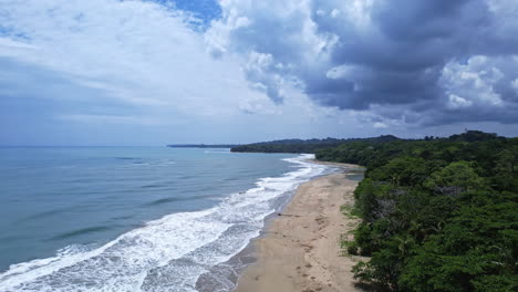 Stunning-aerial-perspective-of-the-Caribbean-coast,-beach,-and-tropical-jungle