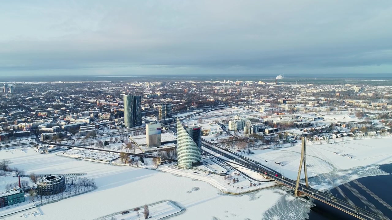 Drone lentää lumisen Riian yllä korostaen siltaa ja ympäröivää arkkitehtuuria.