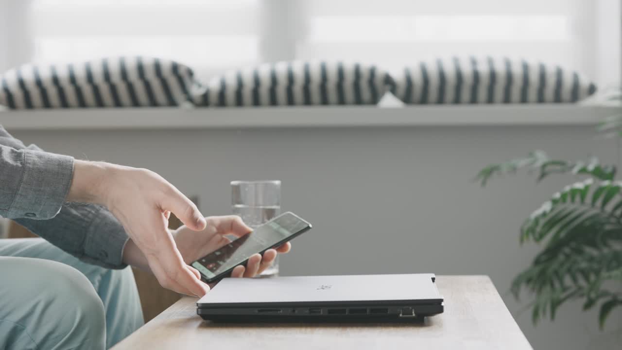 un hombre comienza su día de trabajo desde casa. las manos masculinas abren una computadora portátil moderna.