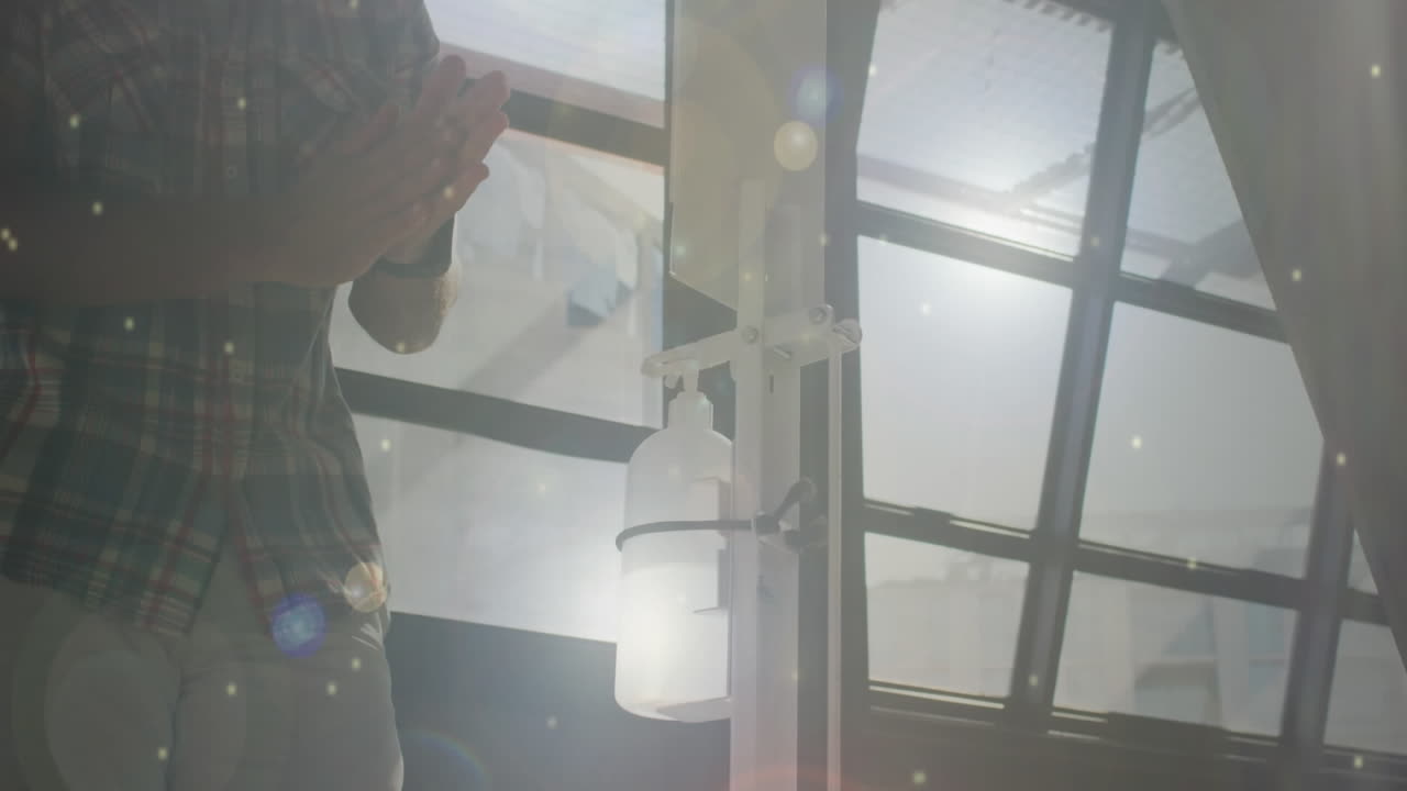 얼굴 마스크를 착용하고 손을 소독하는 아프리카계 미국인 남성 위의 빛의 반점 애니메이션