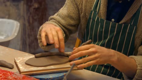 male potter molding a clay