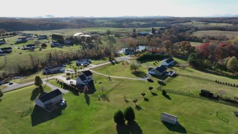 large real estate houses near lake in rural landscape of virginia. sunny day in fall season with grass fields. aerial top down shot. wide shot.
