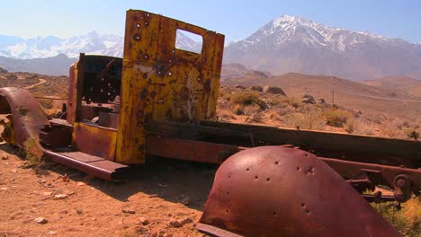 Panning-shot-beside-an-abandoned-pickup-truck-with-the-snowcapped-Sierra-Nevada-mountains-backdrop