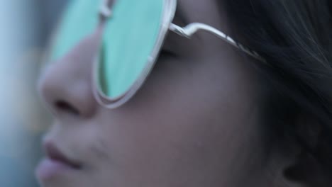 chica posando con gafas de sol grandes y redondas por la noche