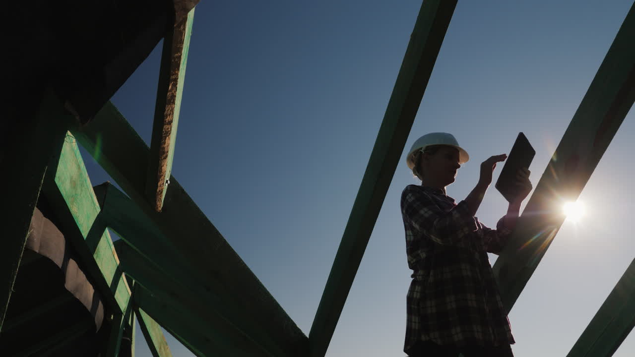 una joven arquitecta ejerce el control del autor en un sitio de construcción usa una tableta