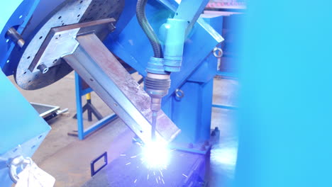 Closeup,-blue-robotic-welder-welding-peace-of-metal