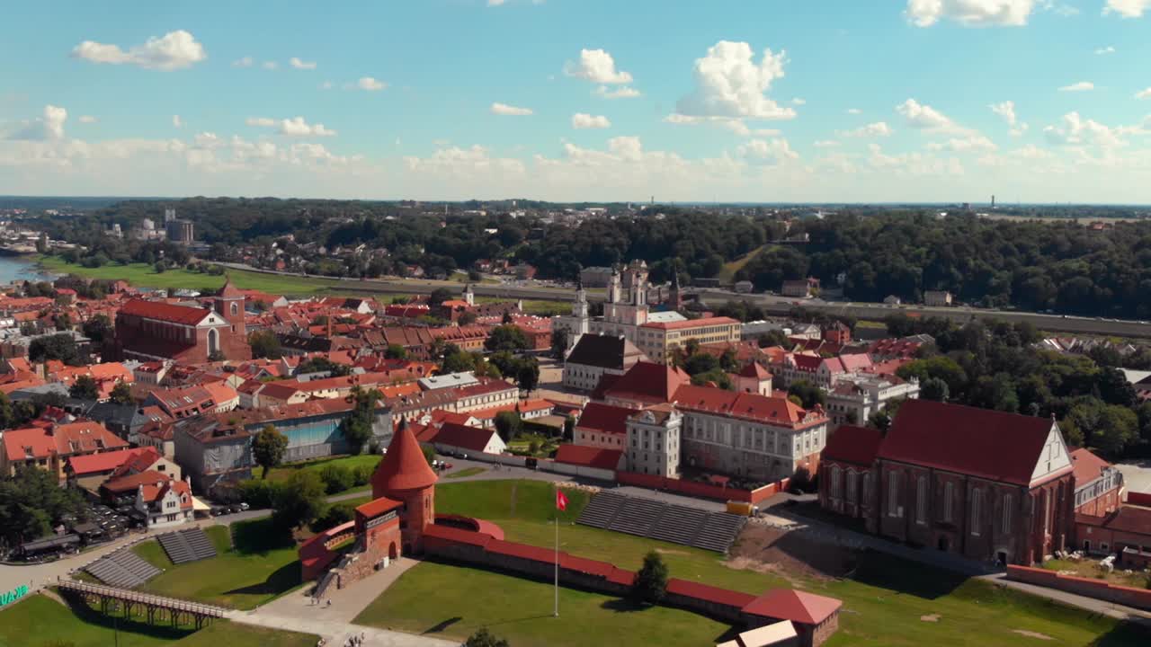 Kaunas city old town aerial drone shot while the drone is flying backward and revealing a beautiful panorama of Kaunas old town, Kaunas castle and churches