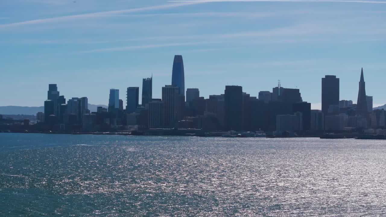 샌프란시스코 시내의 영화적 드론 촬영으로 태양이 물 위에 반사됩니다.