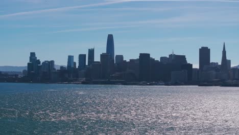 Cinematic-drone-shot-of-downtown-San-Francisco-with-the-sun-reflecting-on-water