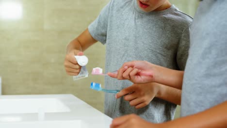 hermanos cepillándose los dientes en el baño
