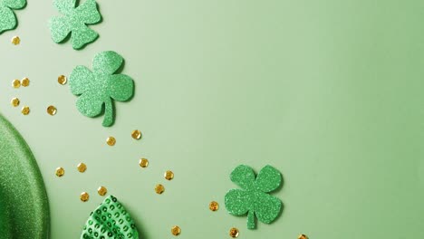 Video-of-saint-patricks-day-green-shamrock,-hat-and-bow-tie-with-copy-space-on-green-background