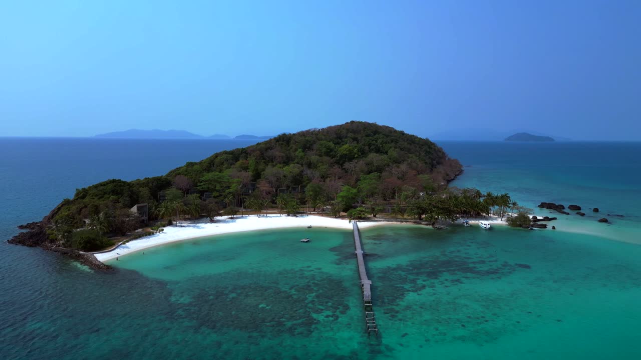 Koh Kham Island with crystal clear turquoise water, white sand beaches and lush tropical vegetation, a popular tourist destination in Thailand. Great aerial view flight panorama orbit drone