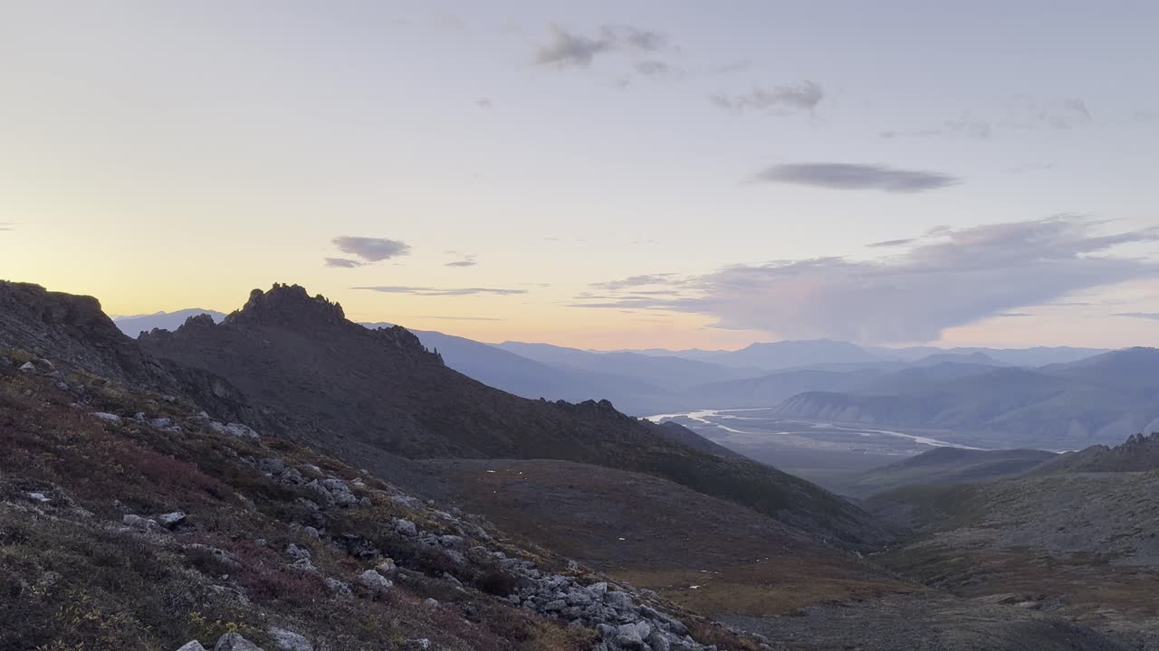 Golden hour illuminates a dramatic mountain landscape