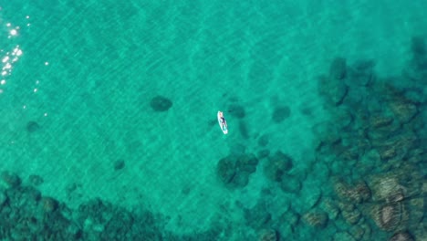 Tourist-Floating-With-Surfboard-In-Turquoise-Beach-Of-South-Lake-Tahoe-In-California,-USA