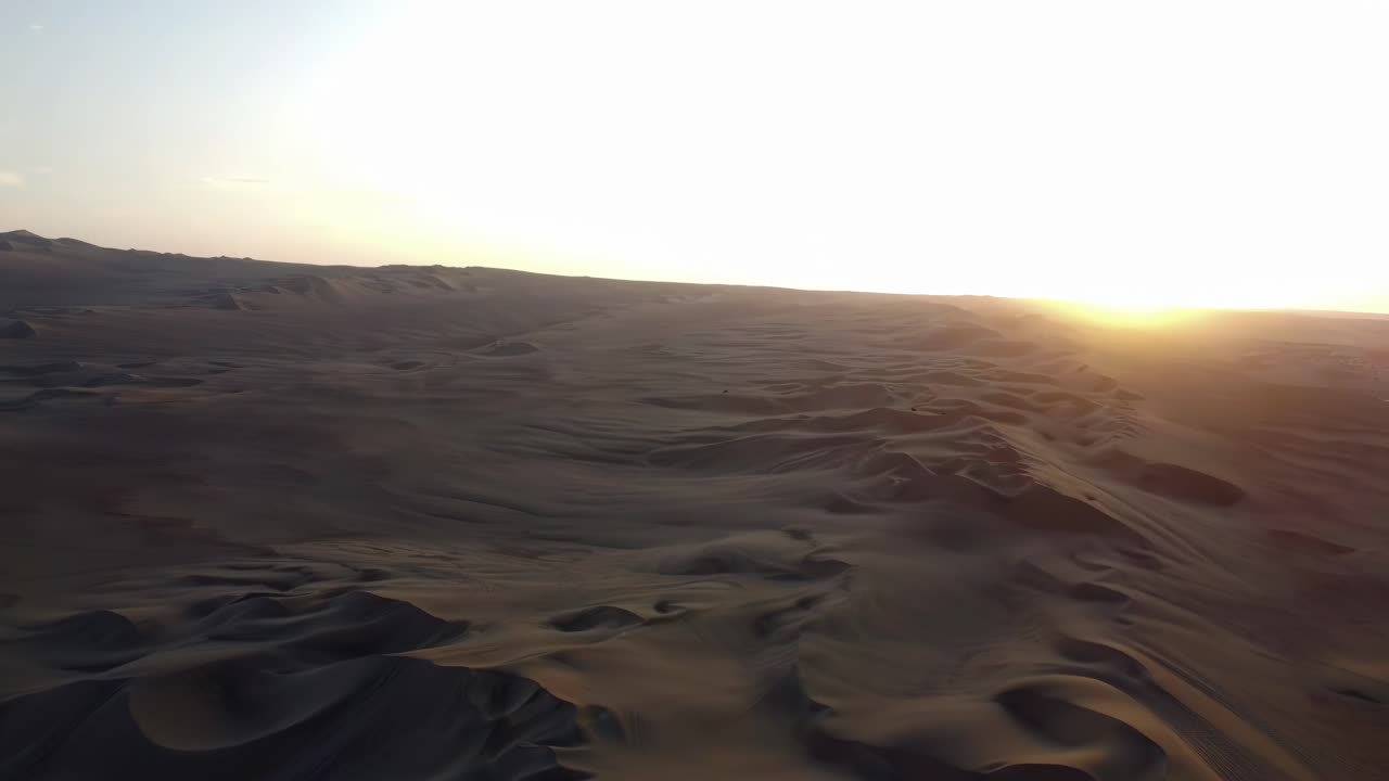 Aerial establishing of Huacachina, Peru, highlighting lagoon amidst vast sand dunes