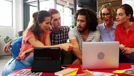 ejecutivos de negocios discutiendo sobre computadora portátil en una reunión