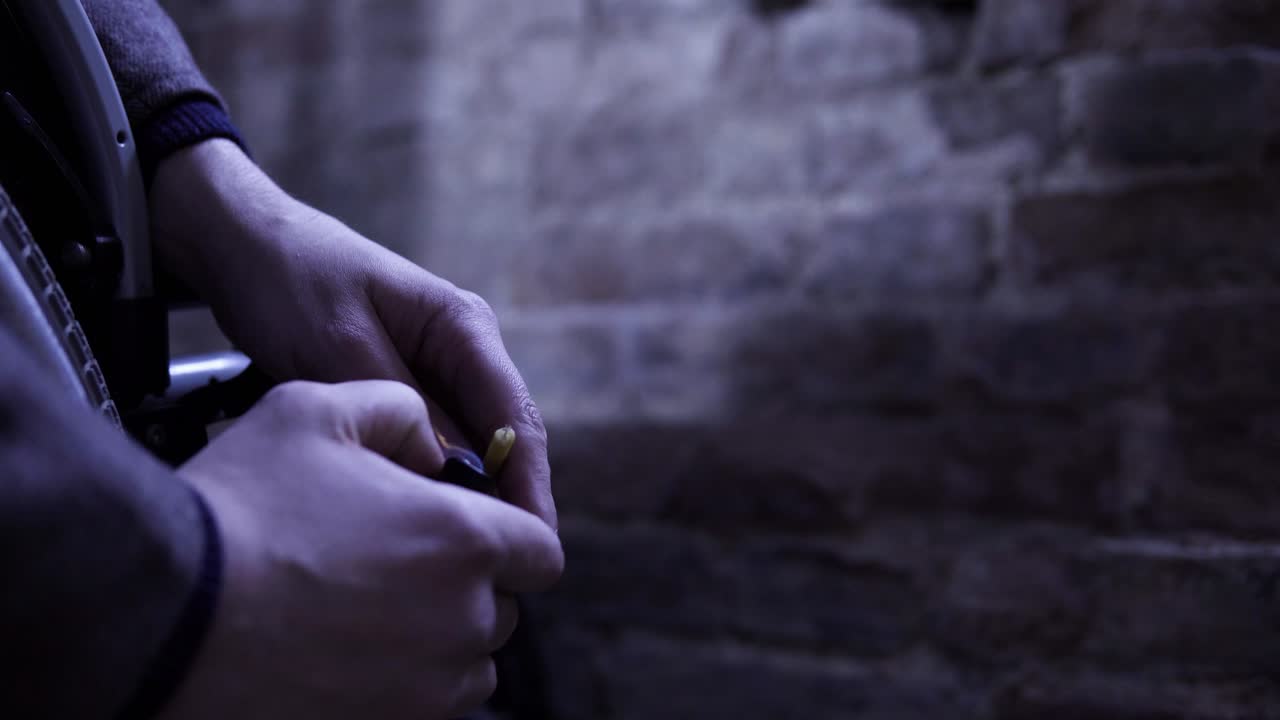 persona en silla de ruedas encendiendo un cigarrillo