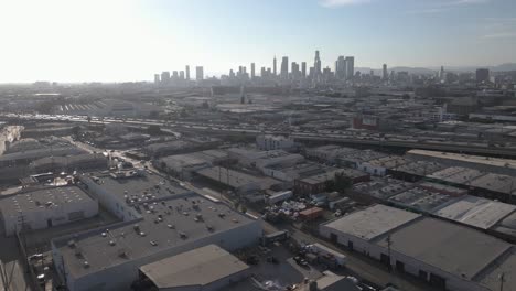 aerial fly over warehouse district and view of los angeles skyline