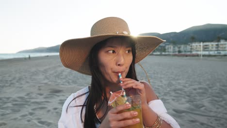 mujer disfrutando de un cóctel en la playa