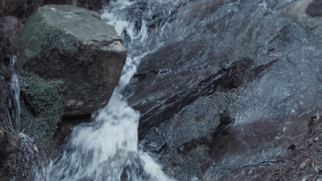 Ruscello di acqua piovana fresca che scorre su roccia calcarea dalla montagna all'interno della foresta