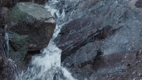 Stream-of-fresh-rain-water-flowing-over-limestone-rock-from-the-mountain-within-forest