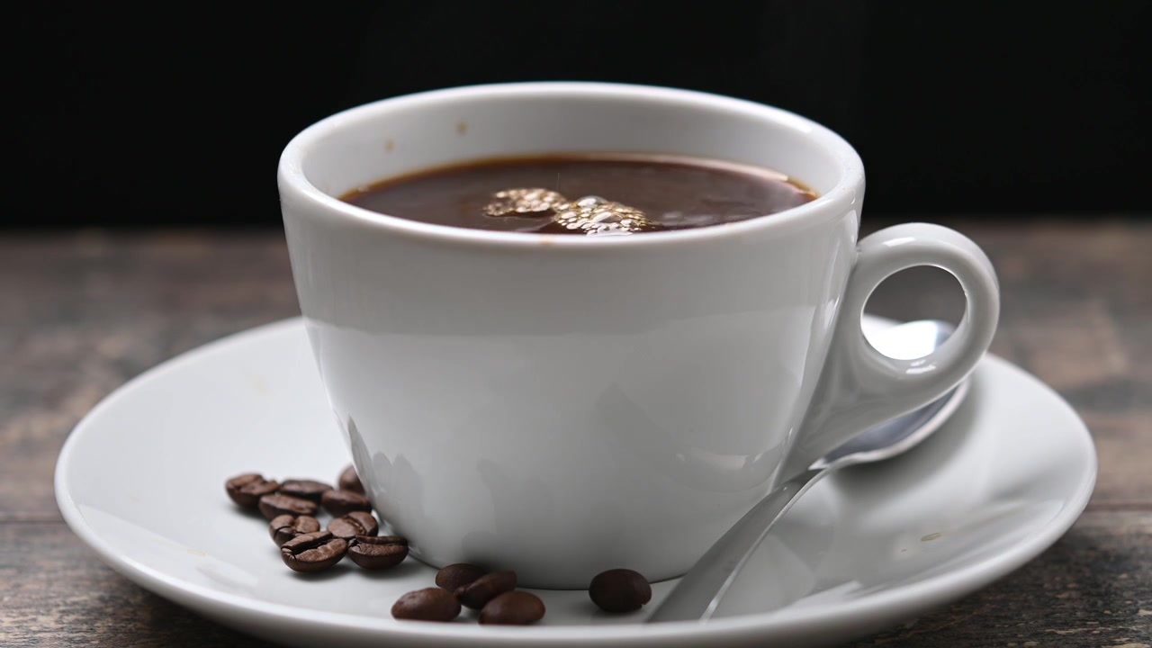 Vertiendo leche en una taza de café caliente.