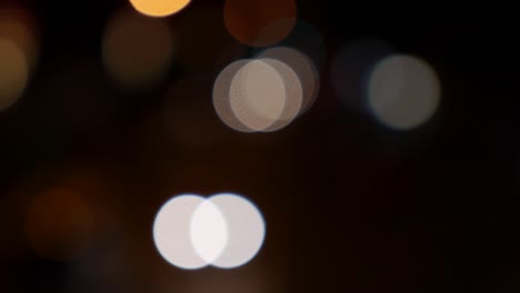 hermoso bokeh brillante en el fondo oscuro borroso por la noche. el redondo bokeh colorido brilla de las luces de los coches en la calle de la ciudad. fuera de foco con borroso. luces de la ciudad sin enfoque. bokeh de tráfico. concepto abstracto