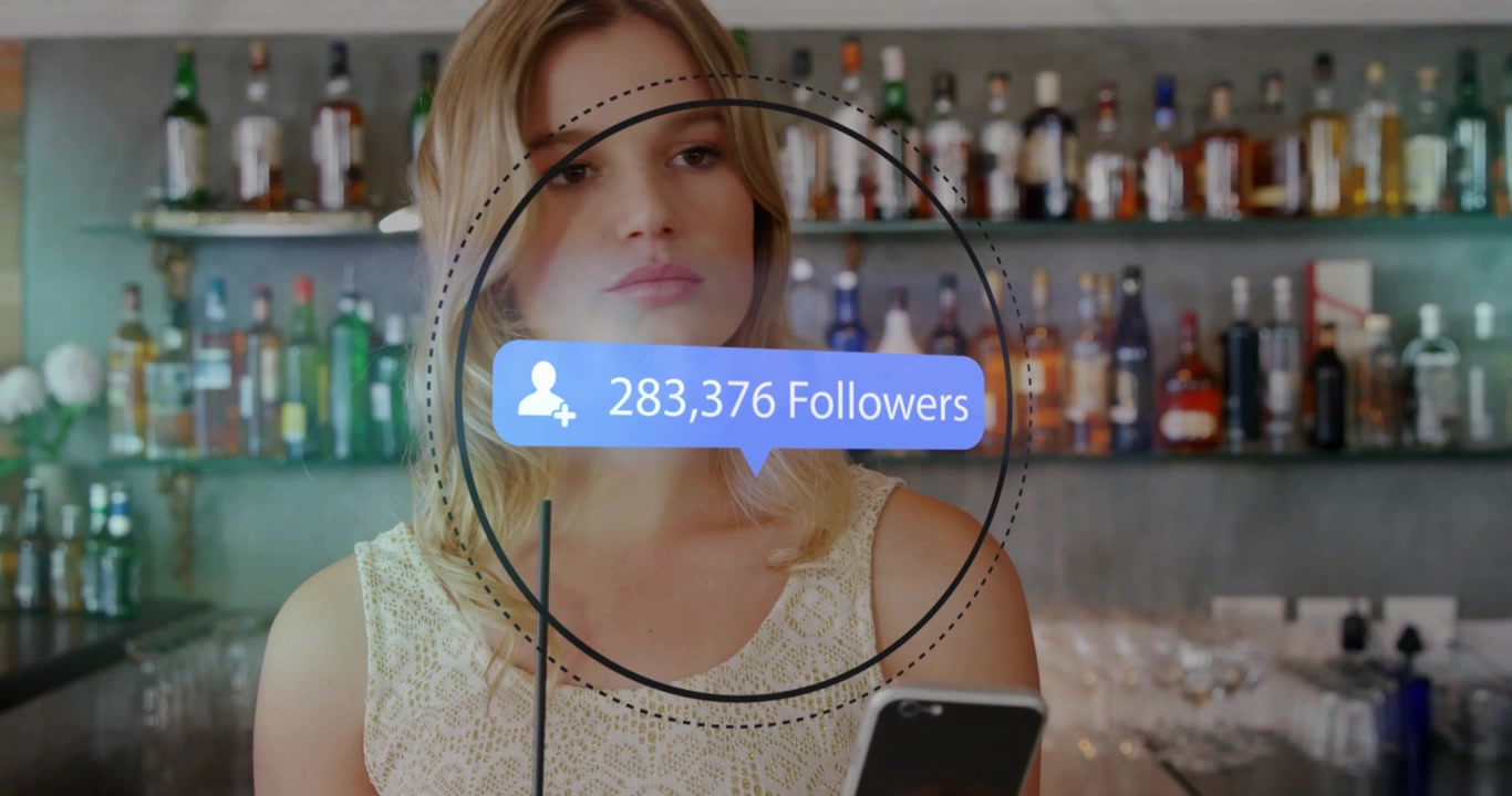 Woman sitting at bar holding smartphone, showing social media follower count circular graphic