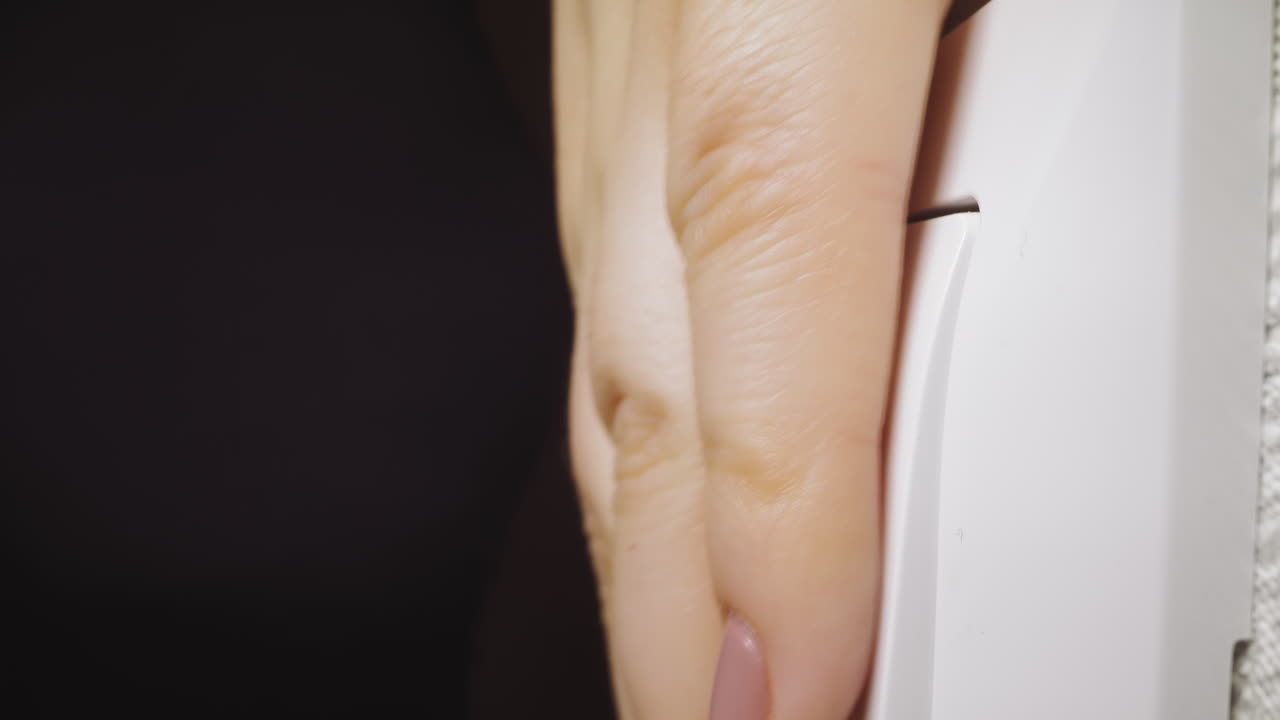 mujer sale del baño y apaga la luz en casa