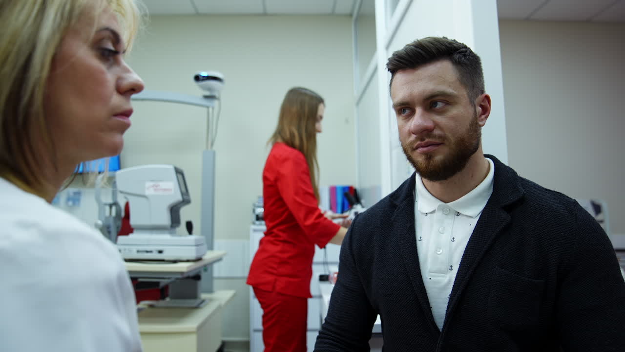 Ophthalmologist consulting young man in clinic. Doctor and patient in modern ophthalmology clinic