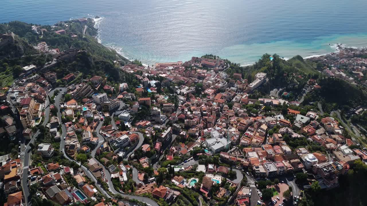Vista aerea da drone su Castelmola e Taormina, Sicilia, filmato cinematografico 4K a 60 FPS che mostra le storiche città collinari, i tetti e la costa mediterranea con vista sul mare