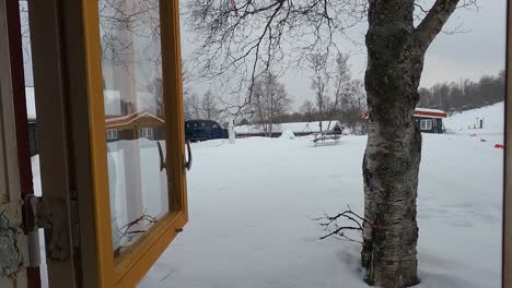 opening window while it's snowing outside of cozy cabin