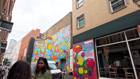 colorful mural with people passing by