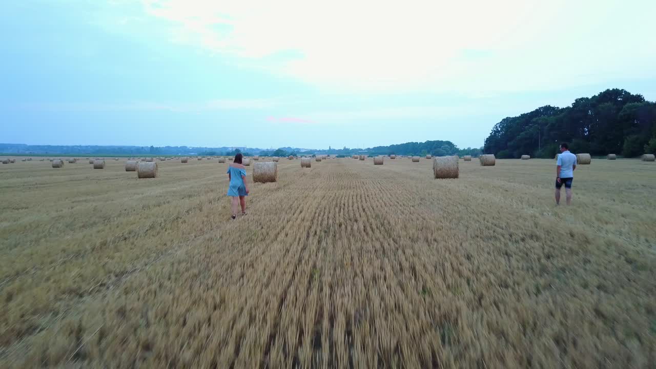 Couple Embracing Near Hay. Happy couple enjoying time in the countryside near hay bales
