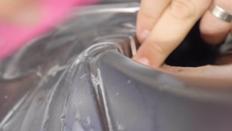 hands using squeegee to apply paint protection film to car's exterior