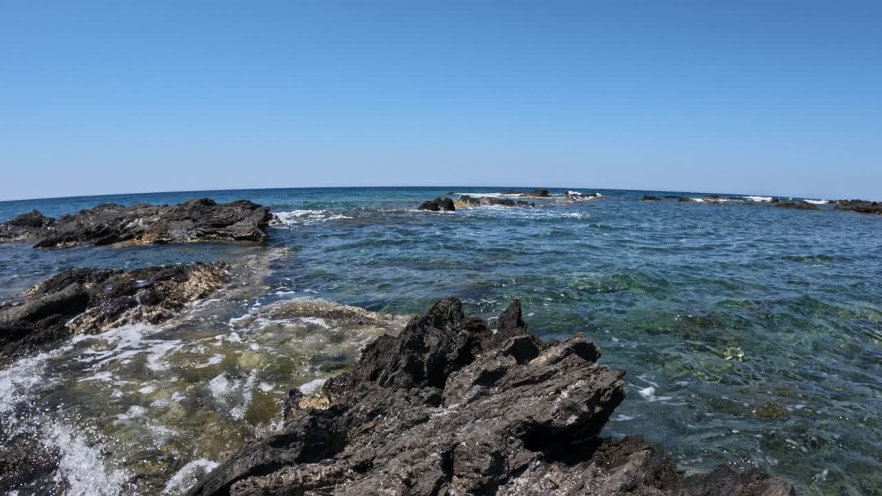 Calm Waves Hit The Rocky Shores Of Chania, Crete, Greece. Wide Shot